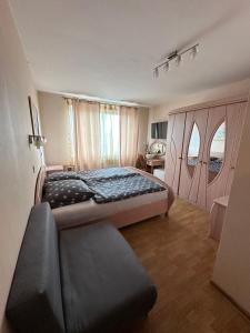 a bedroom with a bed and a couch in it at Oceania Mielno in Mielno