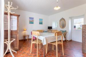 a dining room with a table and chairs at Hortensias - plage 5min en voiture in Plobannalec-Lesconil +18 photos