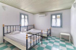 Un dormitorio con dos camas y suelo de cuadros. en Santa Maria Villa in Paros, en Santa Marina 5 fotos más
