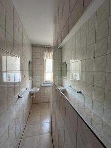 a tiled bathroom with a sink and a mirror at Oceania Mielno in Mielno +46 photos