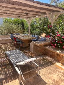a patio with a table and a bench under a pergola at Simos suites in Elafonisos