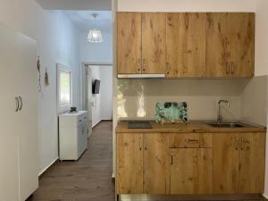 a kitchen with wooden cabinets and a sink at Doris Apartments in Himare