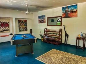 a room with a pool table and paintings on the walls at AVO Boutique Hotel in Dikoni