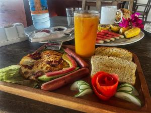 a tray of food with a sandwich and a glass of orange juice at AVO Boutique Hotel in Dikoni