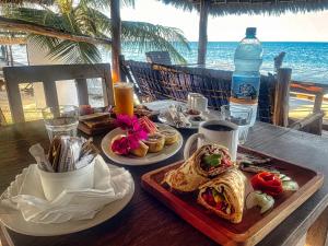a table with two plates of food and a drink at AVO Boutique Hotel in Dikoni
