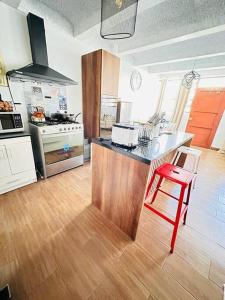 a kitchen with a counter and a red stool at Departamento Vacacional - Pisco Cama Queen in Pisco +2 photos