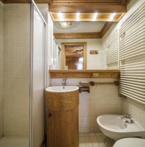 a bathroom with a sink and a toilet and a mirror at Villa Riadezeto - Stayincortina in Cortina dʼAmpezzo