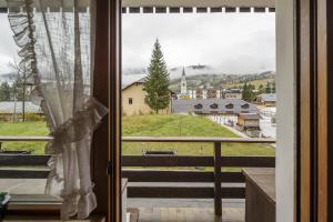 a window with a view of a town with a train at Villa Riadezeto - Stayincortina in Cortina dʼAmpezzo