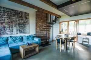 a living room with a blue couch and a table at Pamario rezidencija in Nida