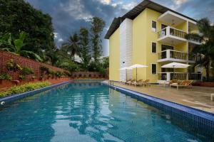 a swimming pool in front of a house at Sea Breeze Sarovar Portico Varca Goa in Varca