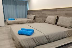 two beds in a room with blue pillows on them at Impian Stay 2 in Kuah