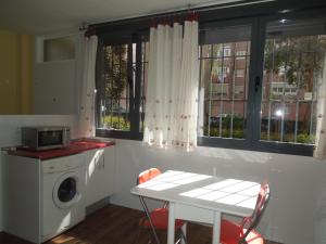 a laundry room with a washing machine and a table at Apartamento Cuatro Torres in Madrid