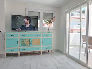 una TV sopra un comò in un soggiorno di Nueva Casa Alhamar a Punta Umbría