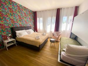 a bedroom with two beds and a colorful wall at The Platform Rooms in Ferrara