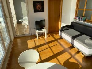 een woonkamer met een bank en een televisie bij Apartment Dunja in Omiš