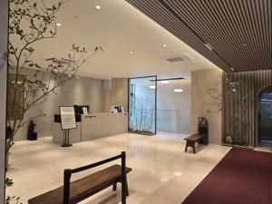 eine Lobby mit einer Bank in einem Gebäude in der Unterkunft N285Hotel in Seoul