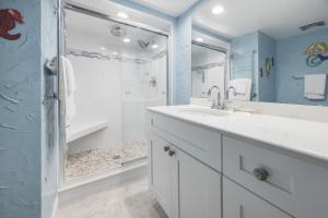 a bathroom with a white sink and a shower at Loggerhead 424 condo in Sanibel