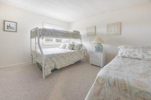 a bedroom with a bunk bed and a bed sidx sidx sidx sidx at Loggerhead 424 condo in Sanibel