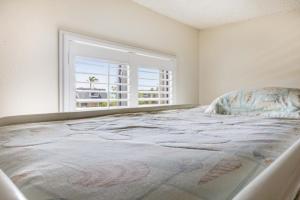 a large bed in a room with a window at Loggerhead 424 condo in Sanibel +12 photos