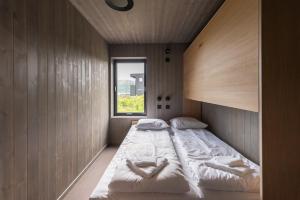 een slaapkamer met 2 bedden en een raam bij Hoda Cabin - Luxury lodge with jacuzzi and sauna in Lyngværet +58 foto's
