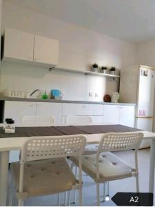 a kitchen with a table and chairs and a refrigerator at San Lorenzo Apartments in Šibenik