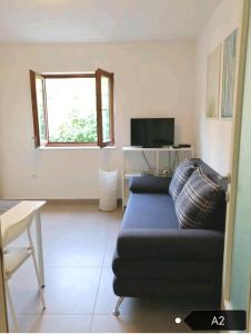 a living room with a blue couch and a window at San Lorenzo Apartments in Šibenik