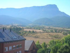 a building with a mountain in the background at Residencia Albergue Jaca in Jaca