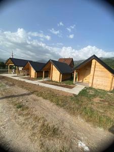 a row of houses in a field next to a road at Kucice za odmor in Plav +6 photos