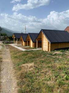 a wooden house with black roofs on a field at Kucice za odmor in Plav