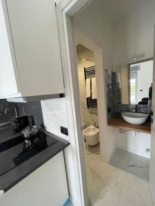 a white kitchen with a sink and a bathroom at Luxury Appartament Como, Lago in Como +3 photos