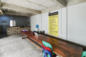 una sala de conferencias con una mesa y sillas de madera en Alfalah Residence Syariah Mitra RedDoorz, en Medan