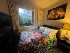 シドニーにあるInner City Luxury Accommodationのベッドルーム1室(カラフルな掛け布団、窓付)