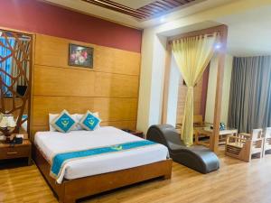 a bedroom with a bed and a chair in a room at Khách Sạn Hoàng Mấm Minh Cầu - Best City view in Thái Nguyên +20 photos