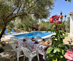 stół i krzesła obok basenu w obiekcie La Mejorana Refugio andaluz con piscina entre olivos w mieście Villanueva de Tapia
