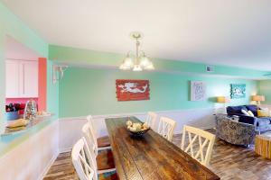 a dining room with a wooden table and chairs at Summer House West Condos in Gulf Shores