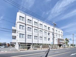 un edificio bianco sul lato di una strada di Okasan Hotel a Ogaki