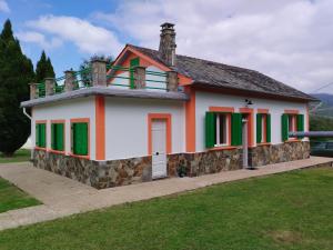 a small house with green shutters on it at los Ojos de Bel in Trevías