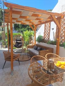 a patio with a wooden pergola and tables and chairs at Vithos in Agnontas