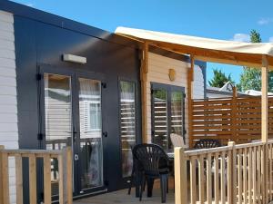 a black shed with chairs and a table on a deck at Camping les Salins de la Gardiole in Vic-la-Gardiole +6 photos