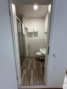a bathroom with a shower and a toilet and a sink at Gasthaus - Hotel Neue Post in Meitingen