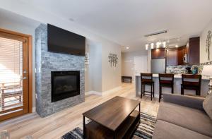 een woonkamer met een bank en een open haard bij Premium Unit 1307 - 1 Bedroom - Zephyr Mountain condo in Winter Park