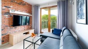 Televízia a/alebo spoločenská miestnosť v ubytovaní Wonder Home - Apartamenty z balkonami, blisko centrum Karpacza, stoku i aquaparku