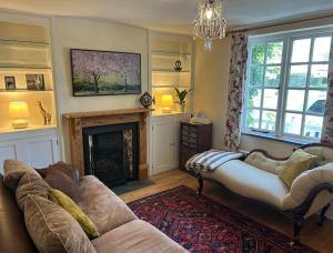 a living room with a couch and a fireplace at Cottage K in Hinxton