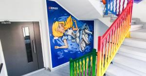 a staircase with a disney mural on the wall at Rise Urban Art Hotel in Larnaca