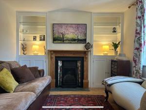 a living room with a couch and a fireplace at Cottage K in Hinxton +4 photos