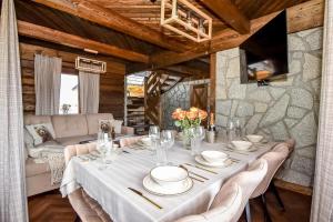 une salle à manger avec une table et des chaises blanches dans l'établissement Osada Góralska Ostoja Pod Gubałówką z Jacuzzi, à Zakopane