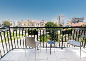 a balcony with chairs and a view of the city at Rise Urban Art Hotel in Larnaca