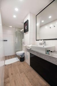 a bathroom with a sink and a toilet and a mirror at Rise Urban Art Hotel in Larnaca