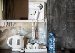 a telephone on a wall next to a bottle of water at Rise Urban Art Hotel in Larnaca
