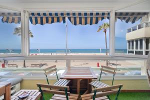 un patio con mesa y sillas y vistas a la playa en Atardecer Beach Apartment, en Cádiz